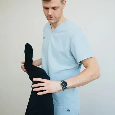 a physiotherapist stretching a patient's leg
