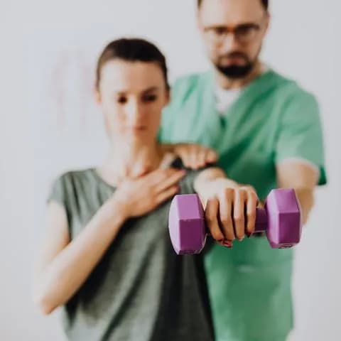 a physiotherapist guiding light dumbbell work