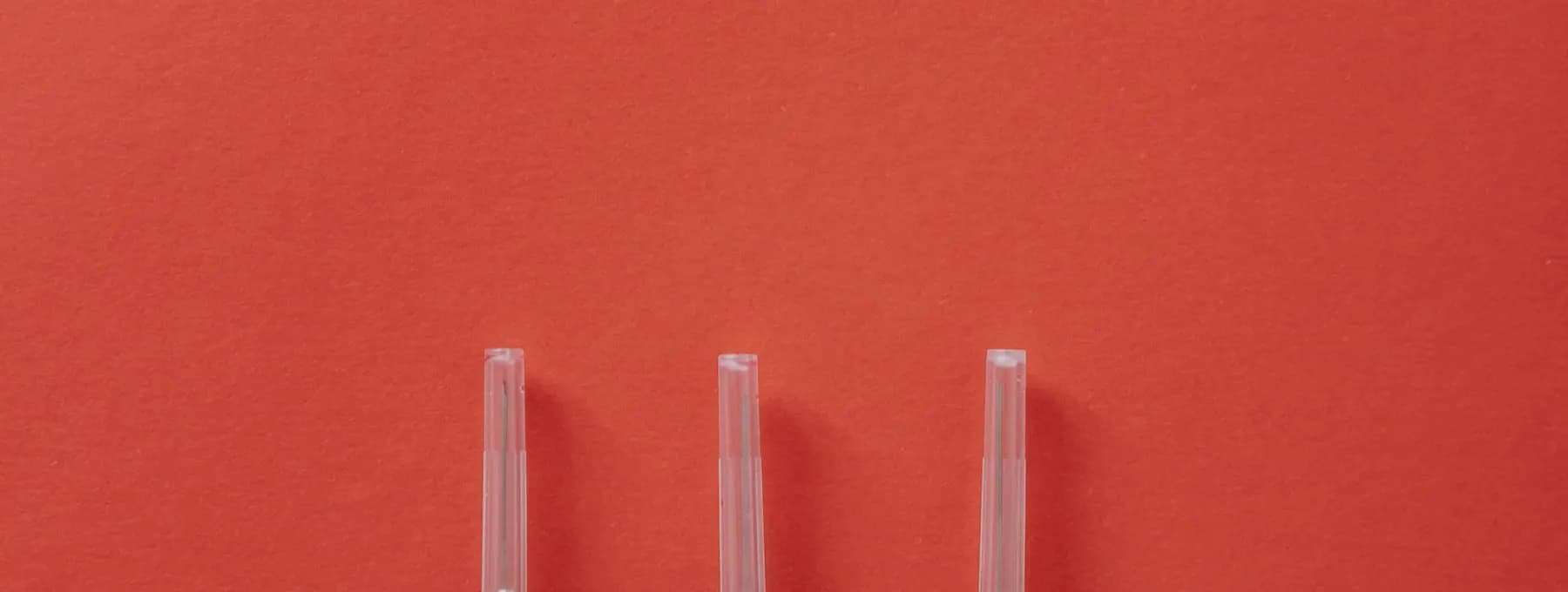 three syringes on a red surface
