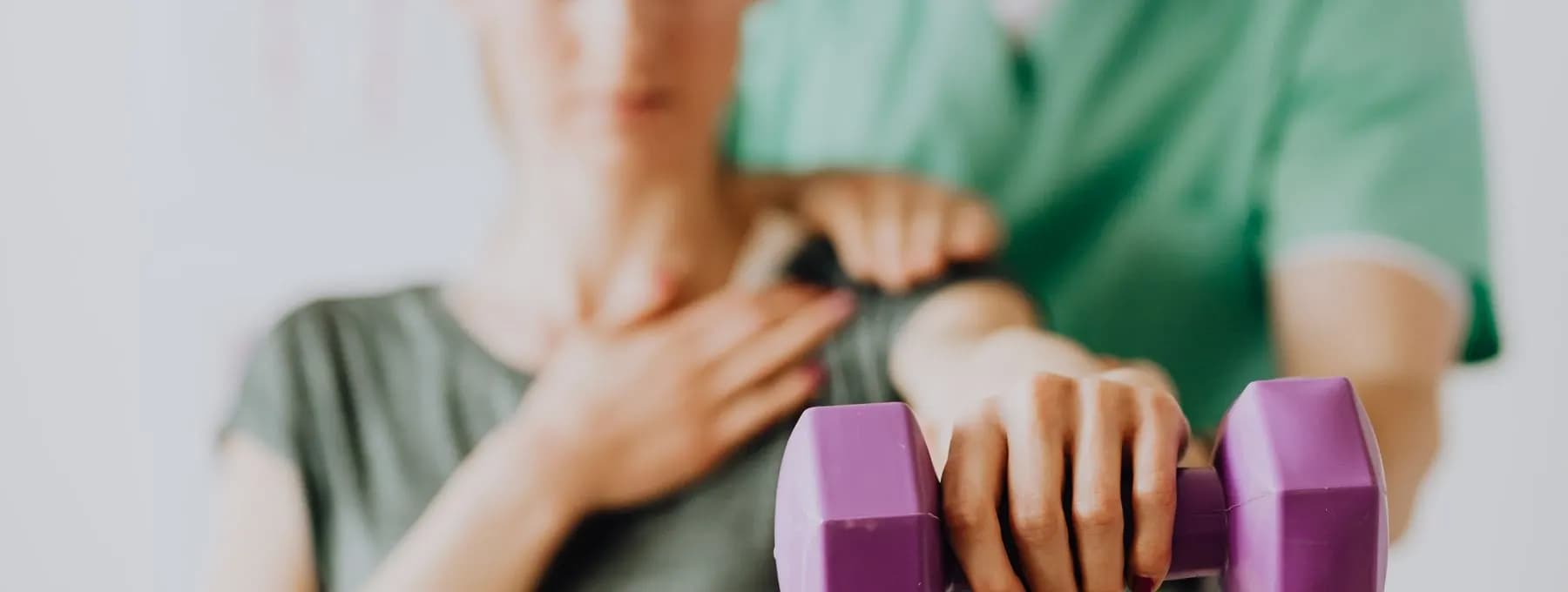 a physiotherapist guiding light dumbbell work