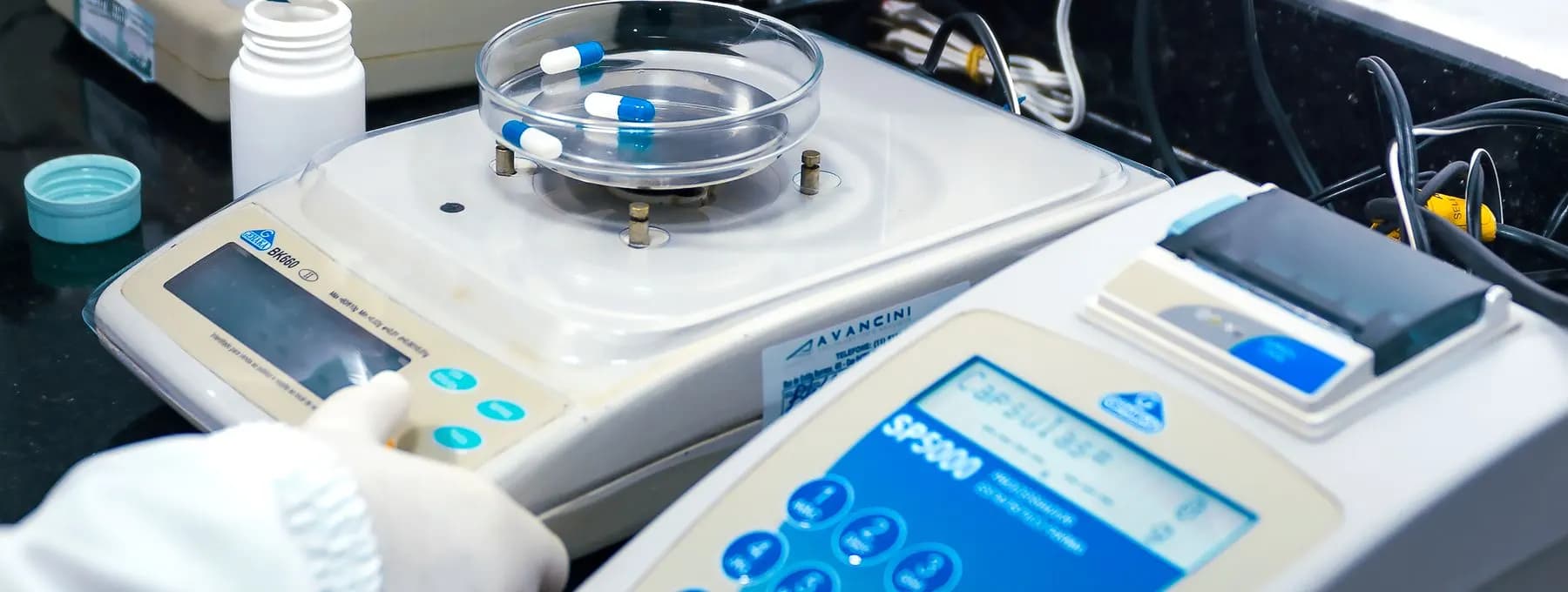 an analytical balance beside sample capsules