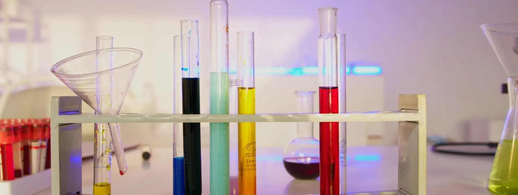 coloured test tubes in a wooden rack